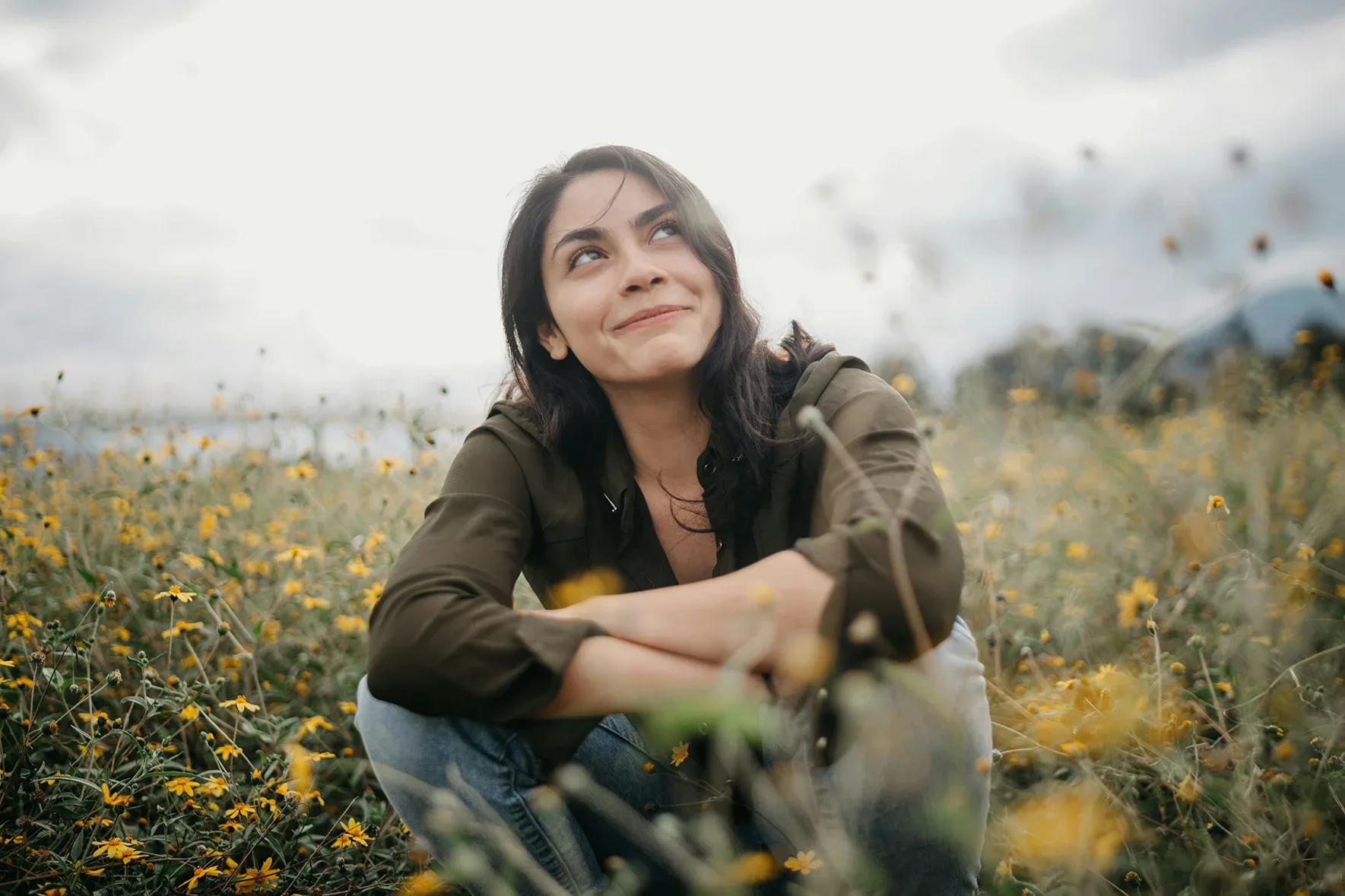 Woman crouching in field of flowers